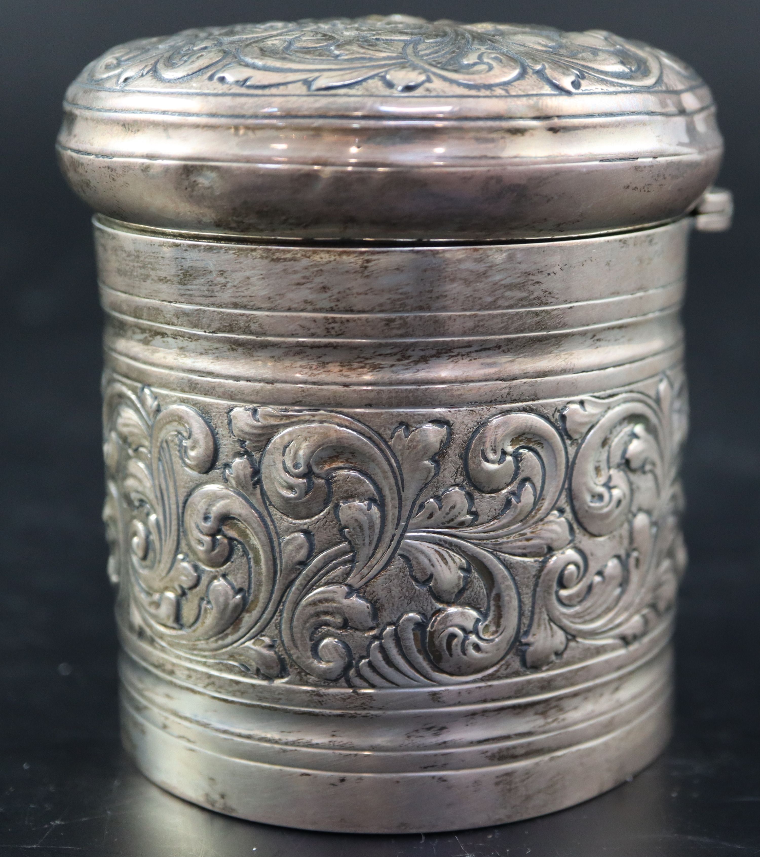 A Victorian embossed silver toilet jar, London, 1887, 93mm, 160 grams and a silver mounted clothes brush.